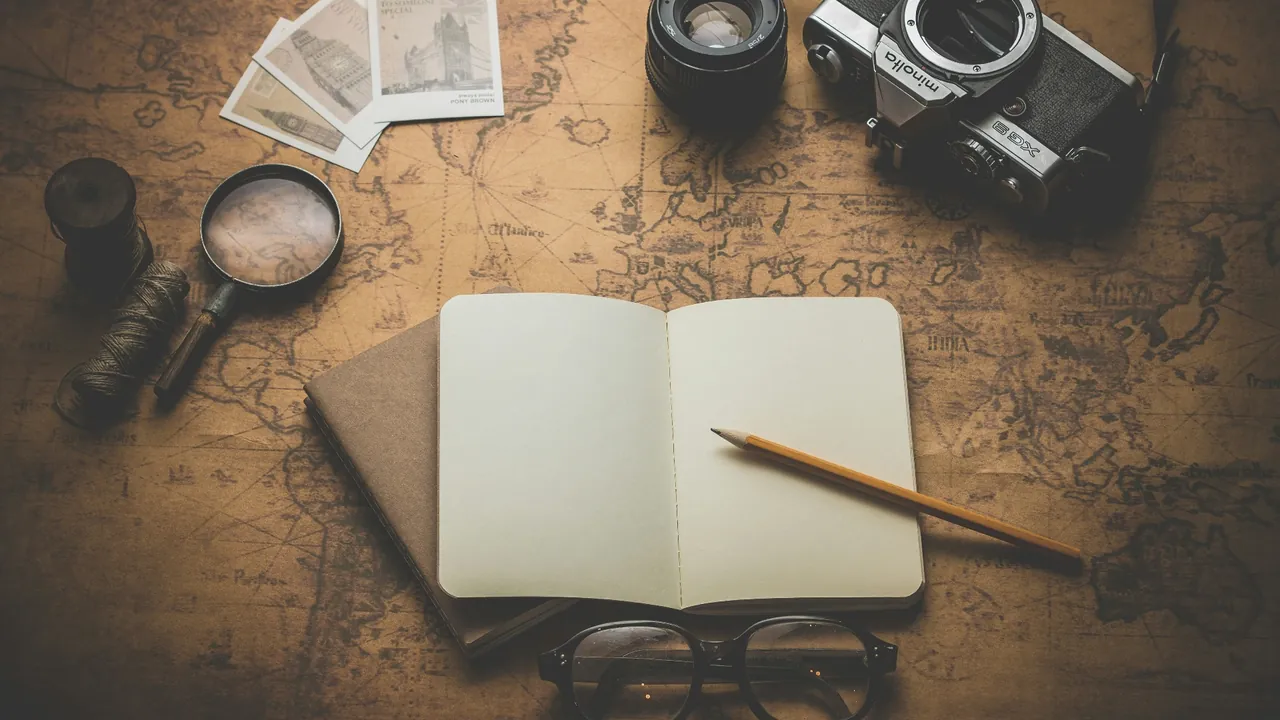 Carnet, loupe, appareil photo et lunettes sur une carte ancienne — accessoires d'aventurier pour un jeu de piste à Paris